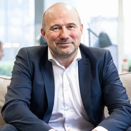 Een man zit op een bank.